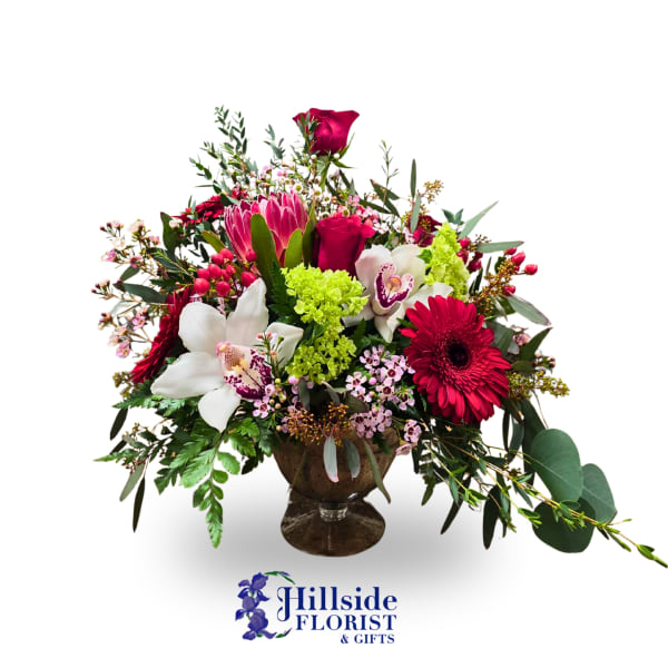 Mixed bouquet in a glass vase with red, pink, white, and green flowers