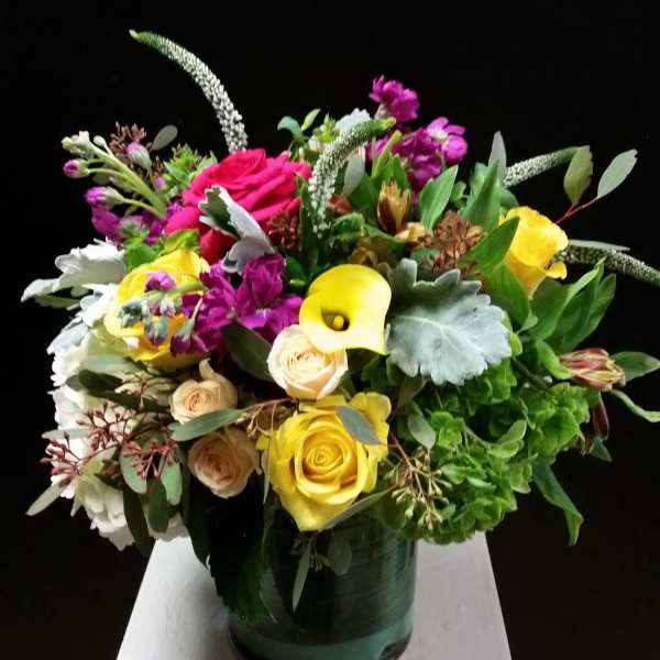 Mixed bouquet with yellow and pink roses in a green vase