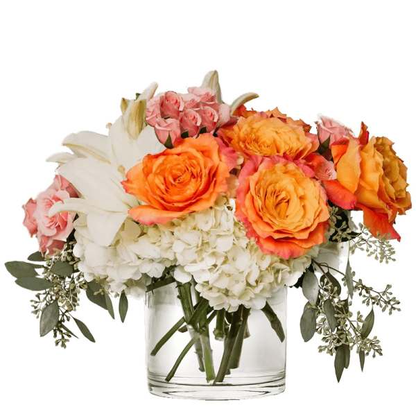 Bouquet of orange and pink roses with white lilies in a glass vase