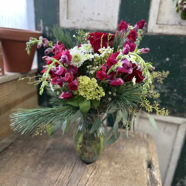 Bouquet of red roses and pink snapdragons in a glass vase