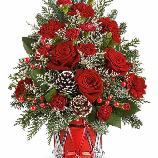 Red roses and carnations in a glass vase with pinecones
