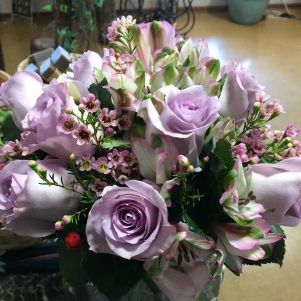 Lavender roses and pink-white alstroemeria in a glass vase with ribbon