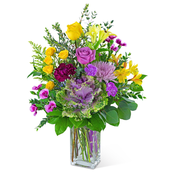 Mixed bouquet of yellow, purple, and pink flowers in a clear glass vase