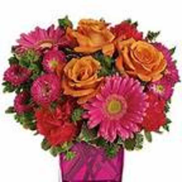 Pink and orange mixed bouquet in a square glass vase