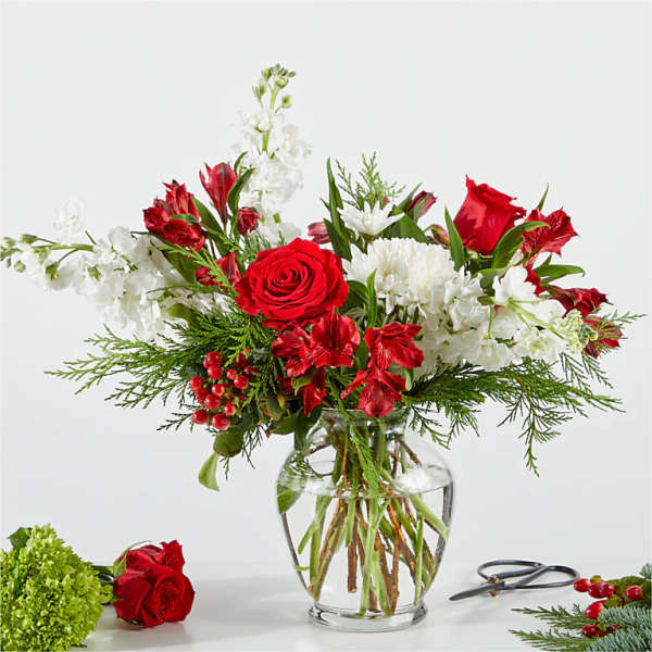 Red and white floral arrangement in a clear glass vase