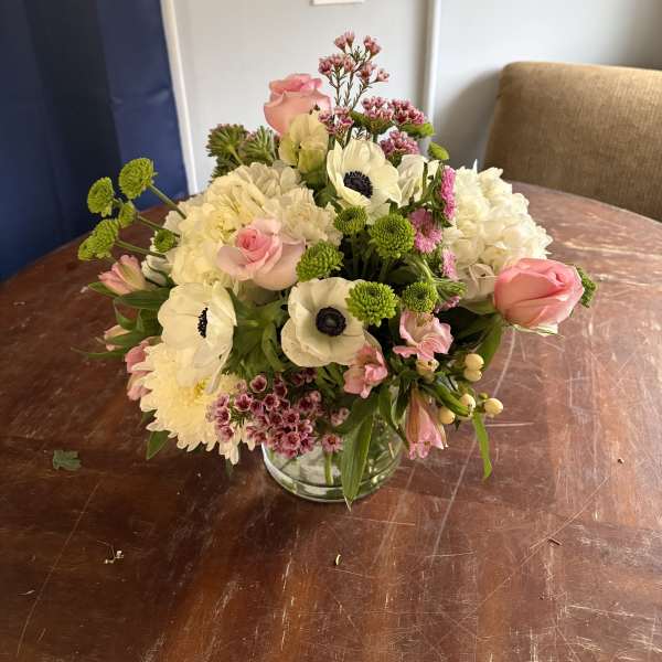 Mixed bouquet of pink and white flowers in a clear glass vase