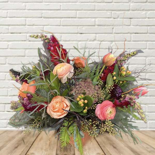 Mixed bouquet of peach and pink flowers in a vase