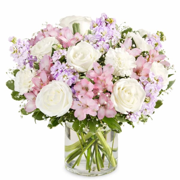 Pink and white bouquet of roses, alstroemeria, and carnations in a glass vase
