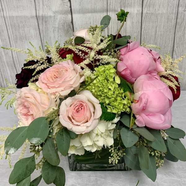 Pink and white roses with peonies in a glass vase