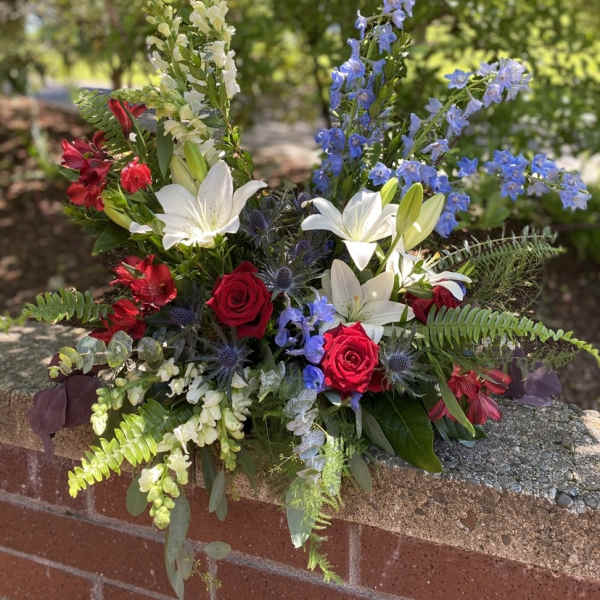 Mixed bouquet with red roses, white lilies, and blue delphinium