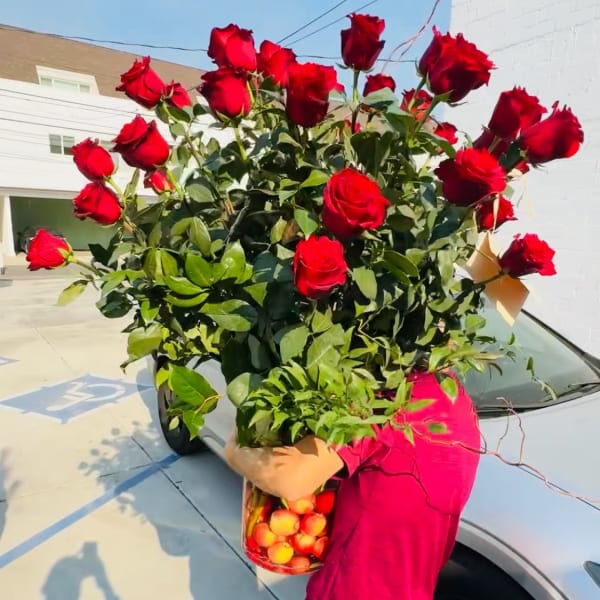 Large bouquet of red roses held outdoors