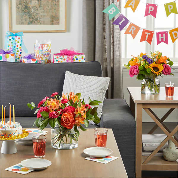 Birthday party scene with two colorful flower arrangements and gifts