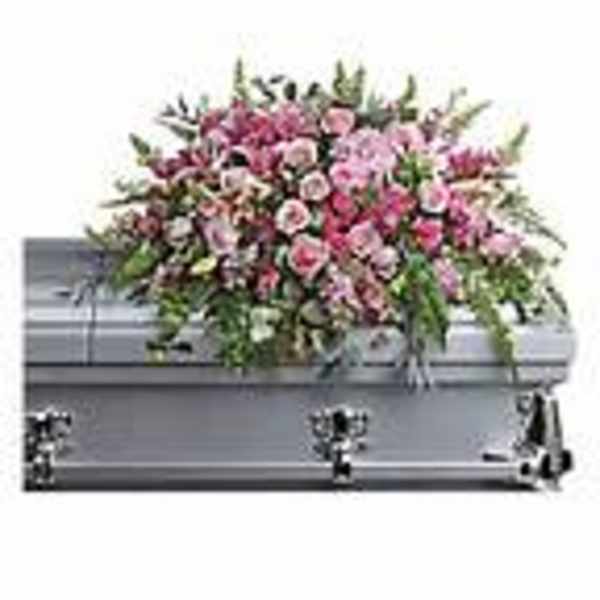 Pink and white floral casket spray on a gray casket