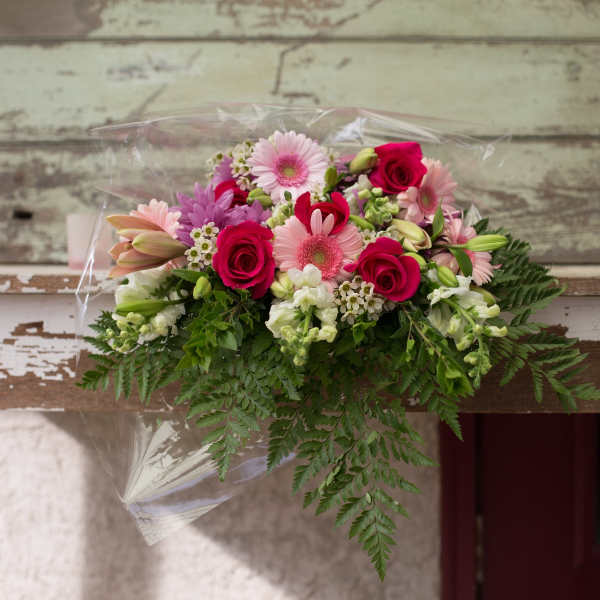 Mixed bouquet of pink and white flowers wrapped in clear plastic