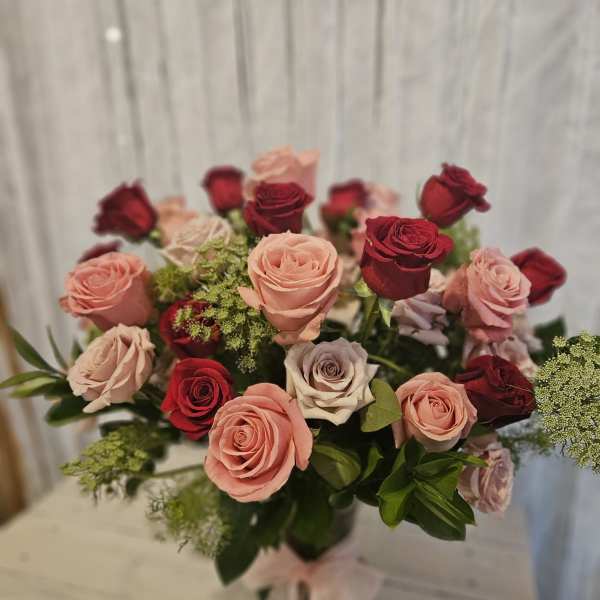 Bouquet of pink and red roses tied with a pale ribbon