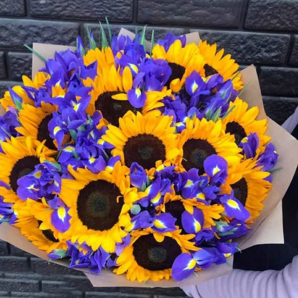 Bouquet of yellow sunflowers and purple irises wrapped in paper