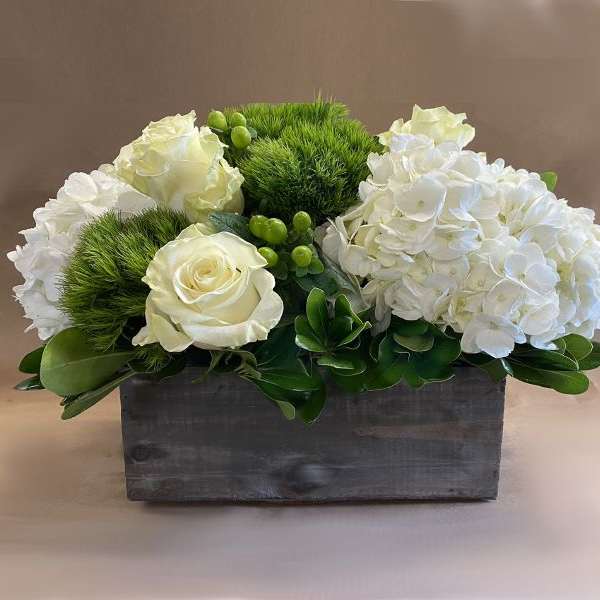 White roses and hydrangeas in a rectangular wooden box