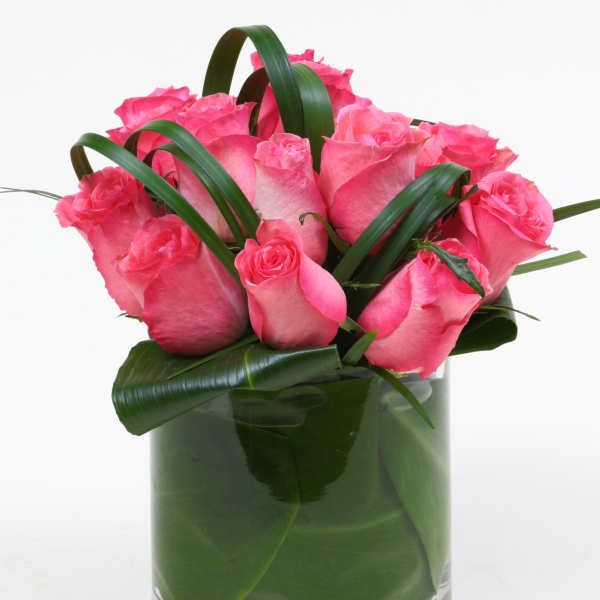 Pink roses arranged in a clear glass vase