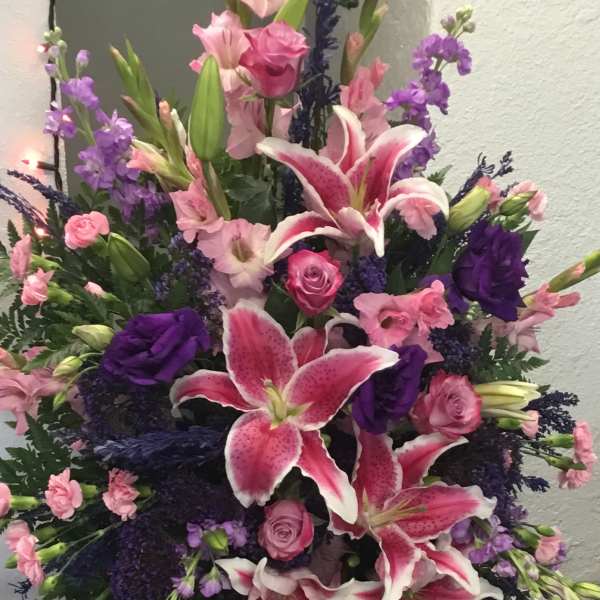 Tall pink and purple floral spray with lilies and roses