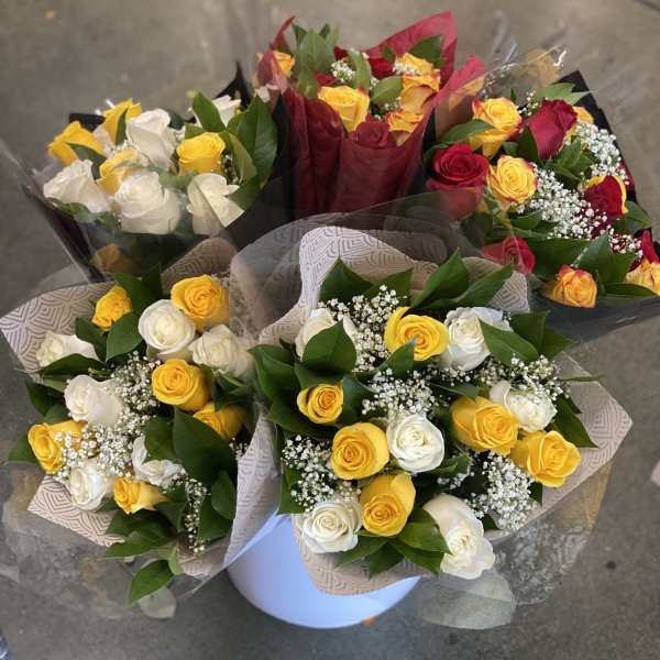 Bouquets of red, yellow, and white roses wrapped in paper