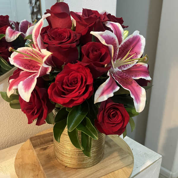 Red roses and pink lilies in a gold vase