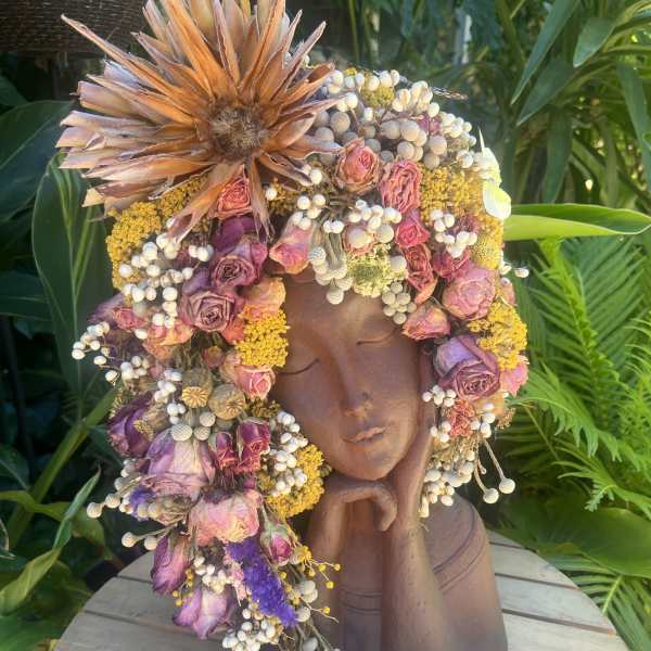Floral crown on a sculpted bust with pink and purple dried flowers