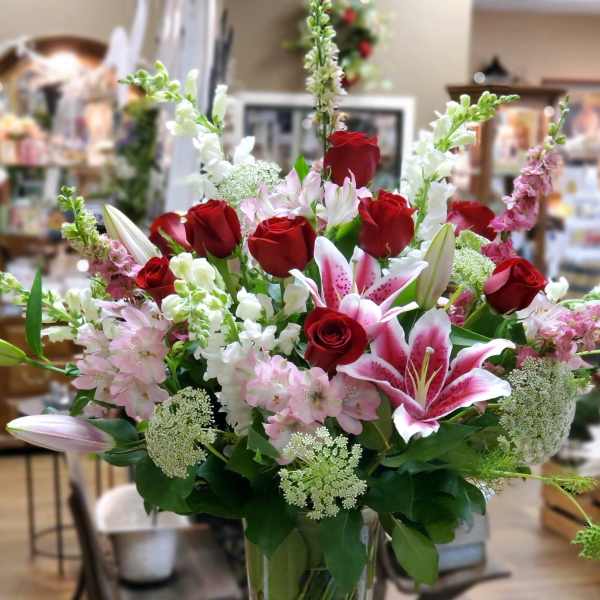 Red roses and pink lilies in a clear glass vase