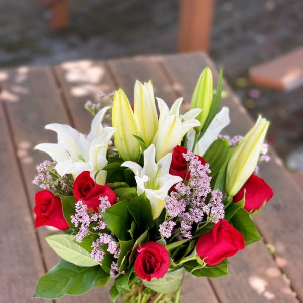 Bouquet of red roses and white lilies in a glass vase