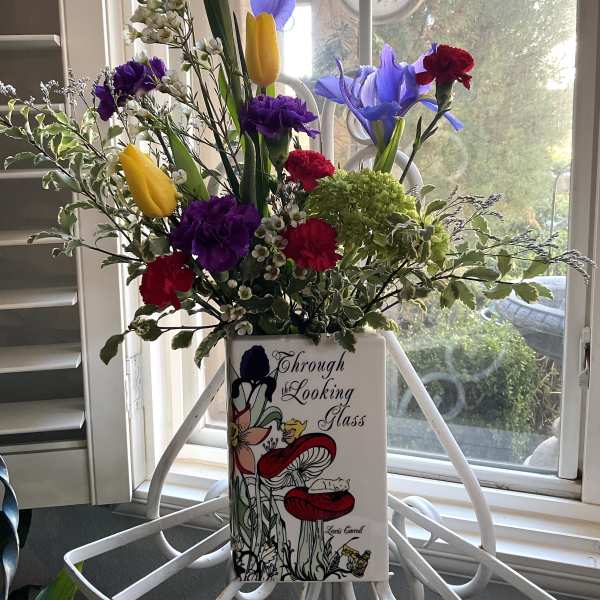 Mixed bouquet in a decorative vase with blue irises and yellow tulips