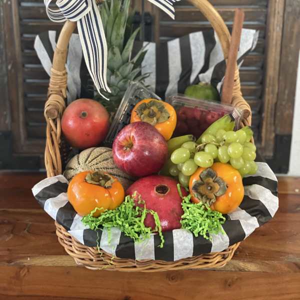Fruit basket with apples, grapes, persimmons, and a ribbon bow