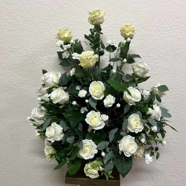 White rose arrangement in a tall pedestal vase