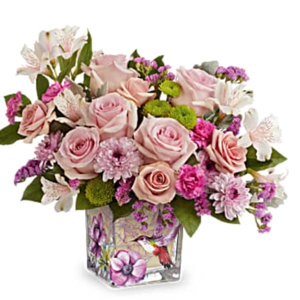 Pink roses and mixed blooms in a decorated glass vase