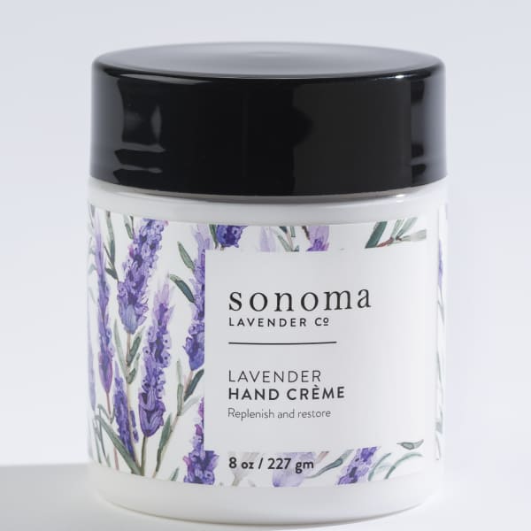 Jar of lavender hand creme with black lid and illustrated lavender sprigs on the label