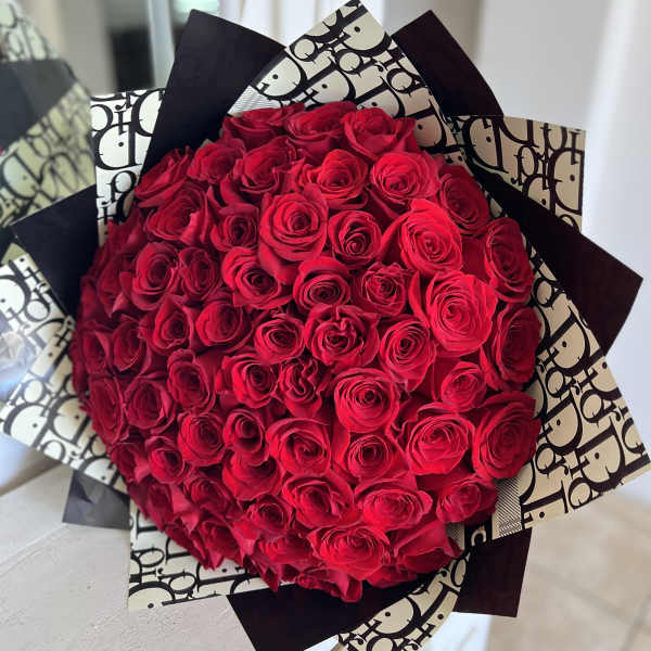 Large bouquet of red roses wrapped in black-and-white paper