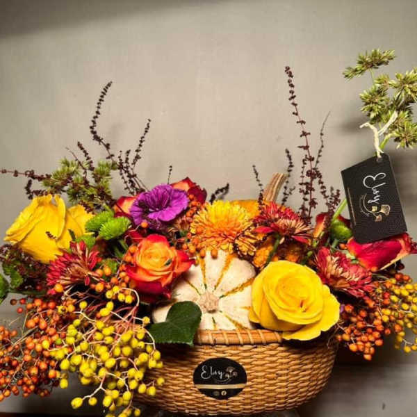 Colorful flower arrangement in a wicker basket with roses and berries