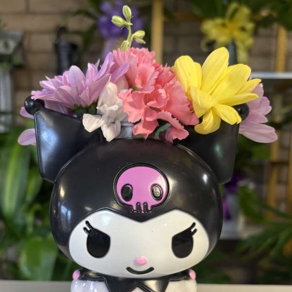 Cartoon cat planter filled with colorful flowers