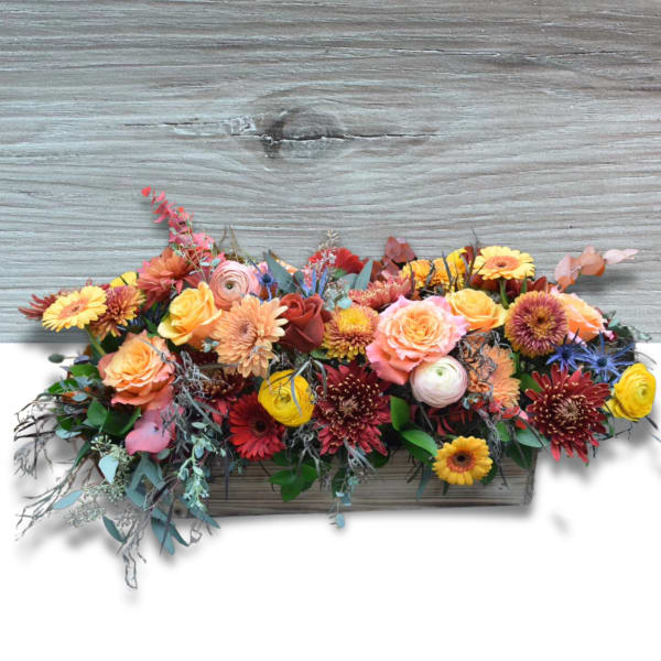 Mixed floral arrangement in a rectangular wooden planter