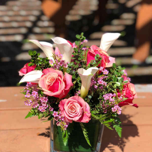 Pink roses and white calla lilies in a glass vase