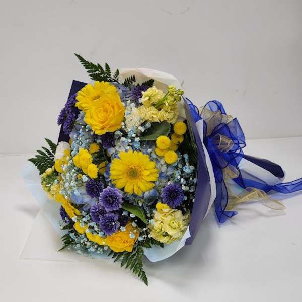 Bouquet of yellow and purple flowers wrapped in blue ribbon
