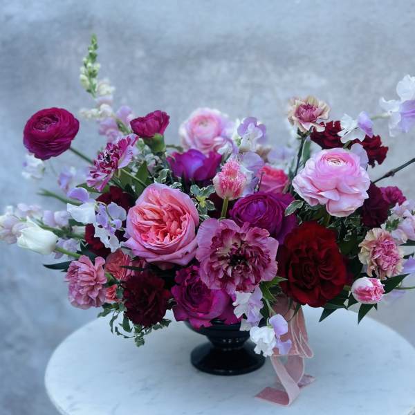 Pink and burgundy mixed bouquet in a black vase