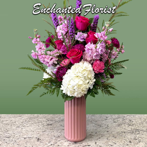 Pink and white floral arrangement in a tall pink vase