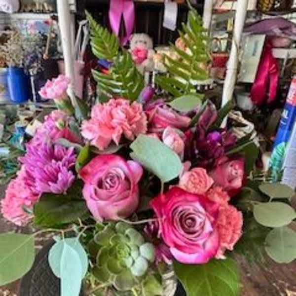 Pink and purple rose bouquet in a glass vase