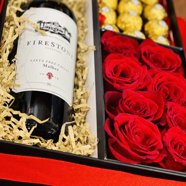 Gift box with a wine bottle, red roses, and gold chocolates