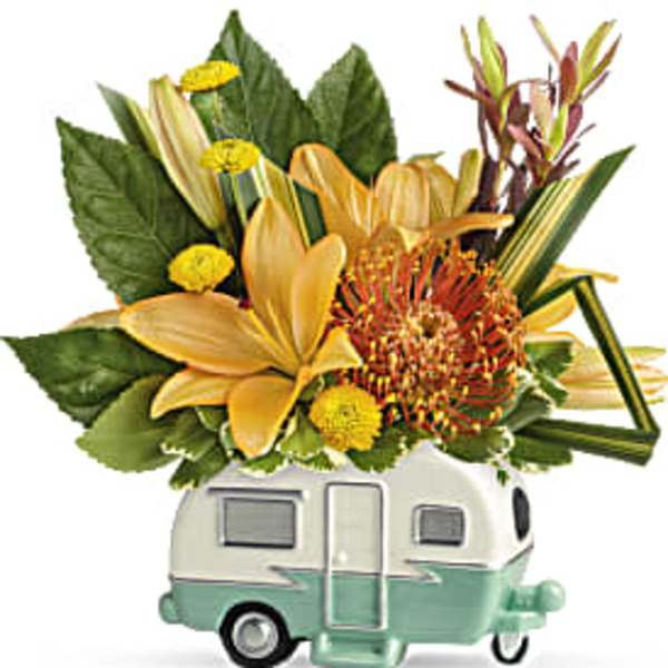 Yellow and orange floral arrangement in a camper-shaped container