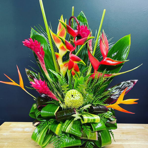 Tropical floral arrangement with red heliconia and pink ginger flowers
