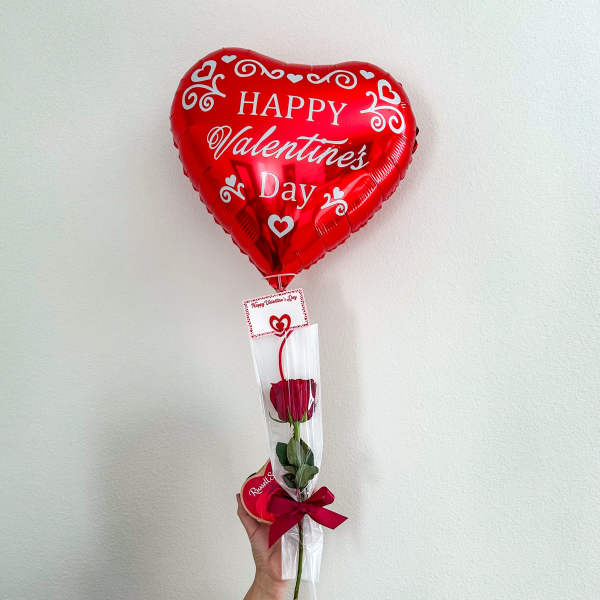 Heart-shaped red Valentine balloon with a single rose in a clear sleeve