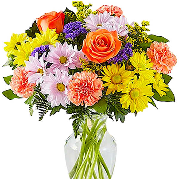 Mixed bouquet of roses, daisies, and carnations in a clear glass vase
