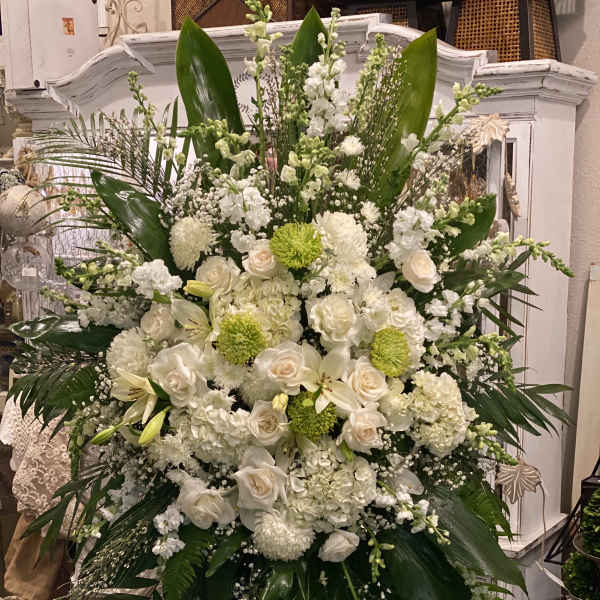 Large white floral standing arrangement with roses and lilies