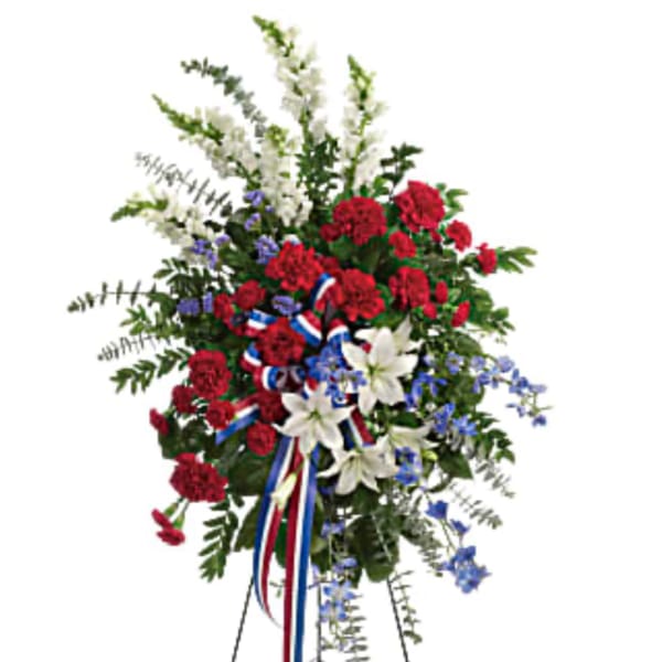 Standing floral spray with red, white, and blue flowers on an easel