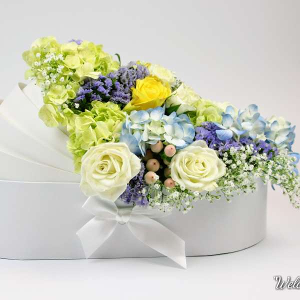 White hatbox arrangement with pastel roses, hydrangeas, and filler flowers